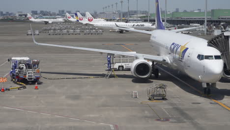 Ground-Crew-Refueling-Commercial-Jet-Boeing-737-Before-Departure-At-The-Airport-In-Tokyo,-Japan