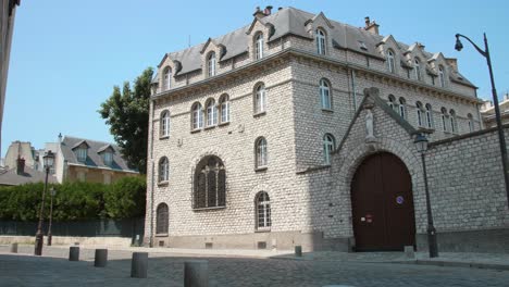 Toma-Panorámica-Del-Monasterio-Carmel-Con-Calle-Adoquinada-En-El-Distrito-De-Montmartre,-París,-Francia