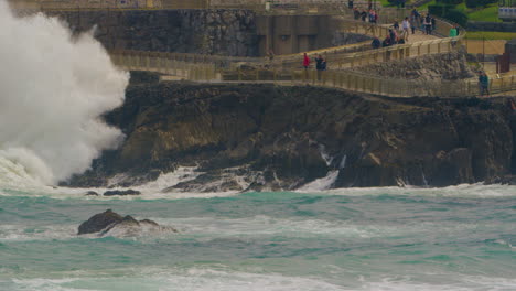 Gente-Viendo-Olas-Masivas-Del-Océano-Golpear-La-Costa-Rocosa,-Tiro-Estático