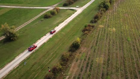 Luftaufnahme-Von-Schwarz-roten-Opel-Grandland--Und-Ford-Kuga-Autos,-Die-Auf-Einer-Landstraße-Rasen