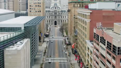 Vista-Aérea-Con-Vistas-A-Una-Calle-Tranquila-En-Filadelfia,-Ayuntamiento-En-El-Fondo---Reversa,-Disparo-De-Drones