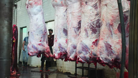 Workers-of-a-SlaughterHouse-joke-amidst-hanging-beef-bodies