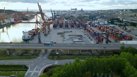 Aerial-follow-shot---Truck-trailer-transporting-cargo-from-Gdynia-Cargo-Container-Terminal-at-sunset