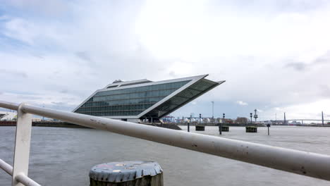 Tiro-De-Hiperlapso-Del-Moderno-Edificio-De-Oficinas-De-La-Zona-Portuaria-En-El-Río-Elba-En-Hamburgo-Durante-Un-Espectacular-Paisaje-Nublado-En-Movimiento