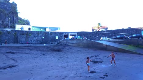 Two-Young-Boys-Playing-And-Throwing-Sand-On-Each-Other-At-Seixal-Beach-In-Portugal