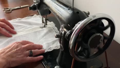 Manos-De-Una-Mujer-Cosiendo-En-Una-Antigua-Máquina-De-Coser-Sigma