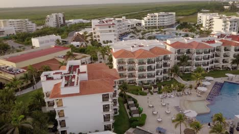 AERIAL---Hotel,-swimming-pool-and-beach-in-Cancun,-Mexico,-spinning-shot