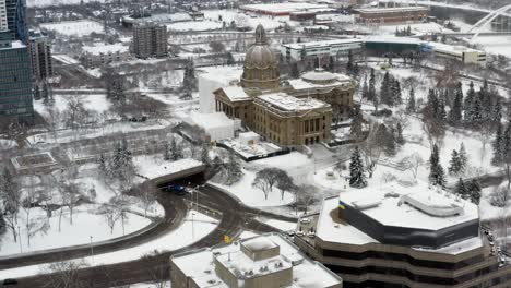 Luftaufnahme-Während-Des-Ersten-Großen-Schneefalls-In-Der-Innenstadt-Von-Edmonton,-Wobei-Die-Britische-Und-Die-Kanadische-Flagge-Im-Parlament-Von-Alberta-Halb-Zu-Ehren-Des-Im-Alter-Von-99-Jahren-In-Großbritannien-Verstorbenen-Prinz-Philip-Von-Edinburgh-Zu-Sehen-Sind