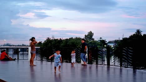 Los-Niños-Pequeños-Y-Sus-Observadores-Disfrutan-De-Un-Paseo-Al-Atardecer-En-Una-Sección-De-La-Explanada-Junto-Al-Río-De-La-Ciudad-De-Iloilo