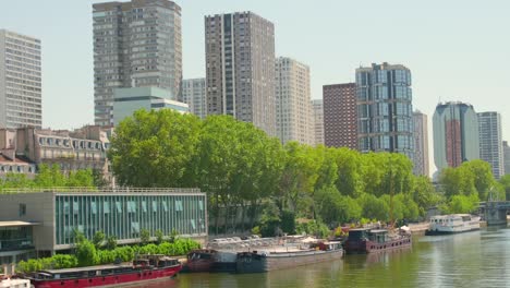 Panorámica-De-La-Cámara-A-Lo-Largo-Del-Río-Sena-Que-Ofrece-Una-Vista-Vívida-Del-Paisaje-Urbano-De-París