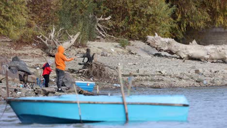 Fisherman-With-A-Fishing-Rod-Catching-Fish-By-The-Shore-Of-Danube-River