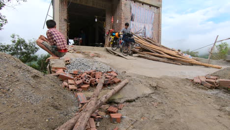 Asiatic-guys-getting-out-of-an-abandoned-house-in-construction,-Vietnam