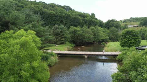 Slow-Aerial-Push-into-Family-fishing-along-the-New-River-near-Boone-NC,-North-Carolina-near-West-Jefferson-NC-in-Watauga-County-NC