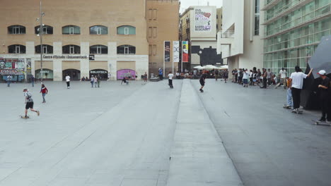 Barcelona---Plaça-Dels-Àngels,-Fuera-Del-Museo-De-Arte-Contemporáneo-Con-Skaters-Haciendo-Trucos-Y-Una-Multitud-Mirando