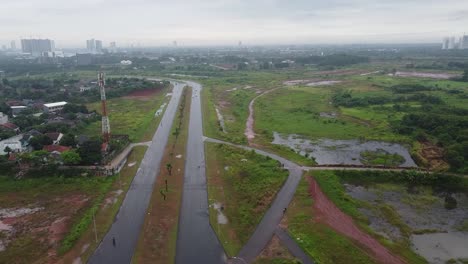 Toma-Aérea,-Una-Carretera-Desierta-Con-Un-Pantano-A-Su-Lado