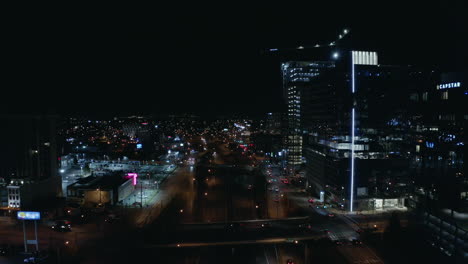 Antena-Nocturna-Sobre-Carretera-Oscura-En-Ciudad-Urbana-Con-Torres,-4k