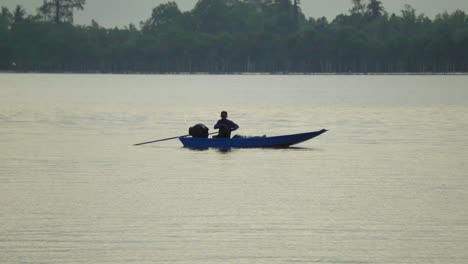 Local-Thai-fisherman-piloting-a-long-tail-river-boat-on-the-Chanthaburi-River,-Thailand