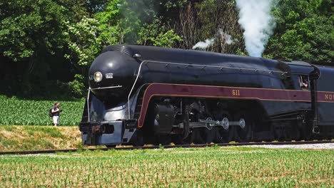 A-Restored-Steam-Engine-Approaching-Blowing-Smoke-and-Steam-Traveling-Thru-the-Countryside-Seen-in-Slow-Motion