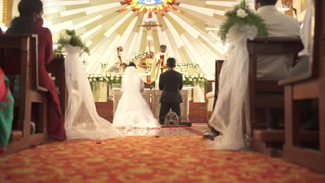 Recién-Casados-Se-Arrodillan-En-El-Altar-De-La-Iglesia-Católica-En-La-Boda-|-Novia-Y-Novio-|-Cámara-Lenta-|-Los-Sacerdotes-Entran