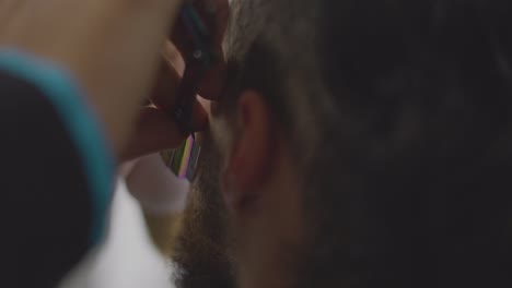 Peluquero-Cortando-La-Barba-A-Un-Joven-Con-El-Pelo-Corto