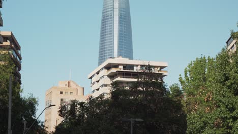 Inclinación-Hacia-Arriba-De-La-Conducción-De-Automóviles-En-El-área-Moderna-De-Sanhattan-Con-El-Rascacielos-Gran-Torre-Santiago-En-El-Fondo,-Chile