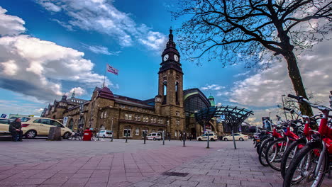 Hyperlapse-shot-of-beautiful-ancient-train-station-of-Hamburg-City-during-sunny-day---Parking-Taxi,rental-bikes-and-traffic-on-road-with-walking-pedestrian