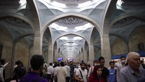 a-group-of-people-walking-with-masks-on-through-a-train-station-in-Tashkent,-Uzbekistan,-slow-motion,-close-up