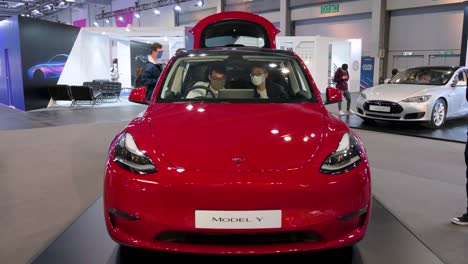 Los-Visitantes-Se-Sientan-Y-Prueban-Un-Automóvil-De-La-Compañía-Eléctrica-Estadounidense-Ev-Tesla-Motors-Car,-Tesla-Model-Y,-Durante-La-Exposición-Internacional-Del-Automóvil-En-Hong-Kong