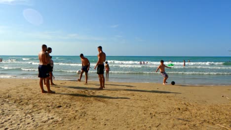 Los-Niños-De-Vacaciones-Se-Divierten-Jugando-Al-Fútbol-En-La-Playa-De-Arena-En-Italia