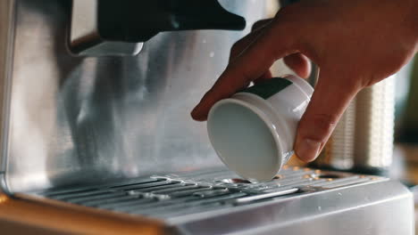 Nahaufnahme-Einer-Hand,-Die-Heißes-Wasser-Aus-Einer-Espressotasse-Gießt