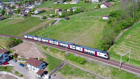 Antena-De-Dos-Trenes-Suizos-Que-Cruzan-En-Lavaux-Vineyard,-El-Tiro-Sigue-A-Uno-Que-Pasa-Por-Encima-Del-Antiguo-Viaducto