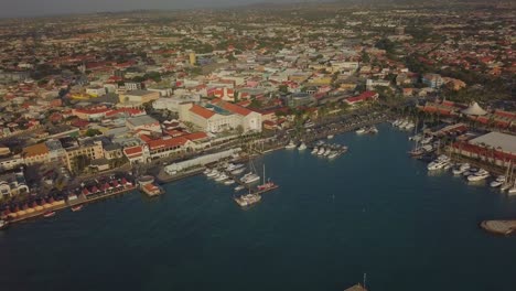 Visión-General-Aérea-Del-Agua-Y-Los-Barcos-En-El-Puerto-Deportivo-Y-Los-Coches-En-La-Concurrida-Calle-4k