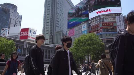 Menschen-Auf-Der-Berühmten-Shibuya-Kreuzung-In-Tokio,-Die-Auf-Der-Straße-Gehen,-Japan