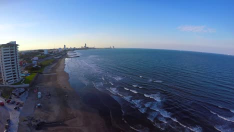 Luftaufnahme-Von-Drony-Mit-Drohne-Des-Strandes-Von-Boca-Del-Rio,-Veracruz,-Mit-Dem-Schatten-Der-Auf-Den-Ozean-Projizierten-Gebäude