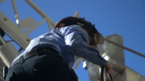 A-female-firefighter-climbs-onto-a-fire-truck-to-operate-a-rescue-ladder