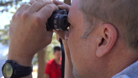 Hombre-Turista-De-4-K-Mirando-La-Mitad-De-La-Cúpula-A-Través-De-Binoculares-En-El-Punto-Del-Glaciar-En-El-Parque-Nacional-De-Yosemite,-California