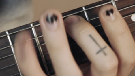 Manos-Con-Un-Esmalte-De-Uñas-Negro-En-Mal-Estado-Tocando-La-Guitarra