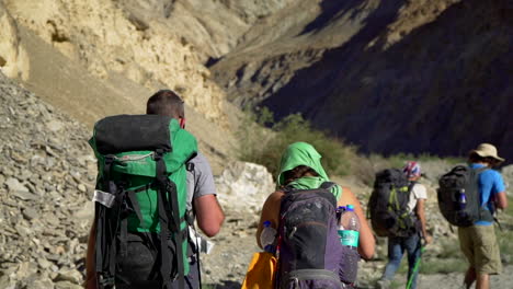 Tracking,-fallowing-medium-shot-of-a-group-of-hikers-in-the-mountains-with-backpacks