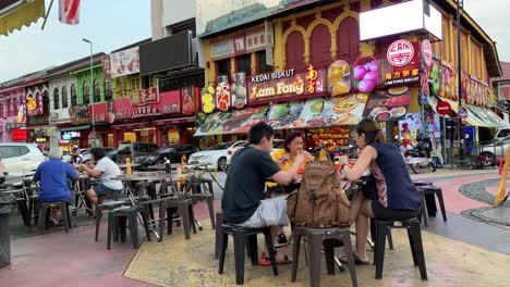 Imágenes-Del-Restaurante-De-La-Ciudad-De-Ipoh-Con-Un-Comedor-Al-Aire-Libre-Y-Gente-Comiendo-A-Lo-Largo-De-La-Calle-Lateral