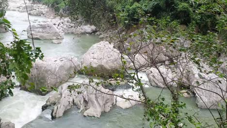 Corriente-De-Agua-Que-Fluye-Con-Terreno-Rocoso-En-Un-Parque-Público