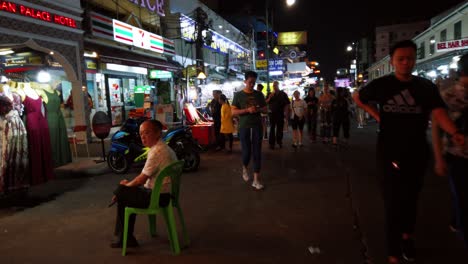 Escenas-De-Mano-De-Los-Turistas-Caminan-Por-La-Calle-Khao-San-En-La-Noche-Famosa-Que-Cada-Año-Turistas-De-Muchos-Países-Venían-A-Visitar-En-Bangkok,-Tailandia