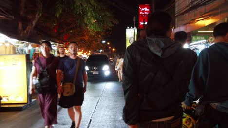 Handheld-scenes-of-the-tourists-are-walking-around-Khao-San-Road-at-night-time-famous-which-each-year-tourists-from-many-countries-came-to-visit-in-Bangkok,-Thailand