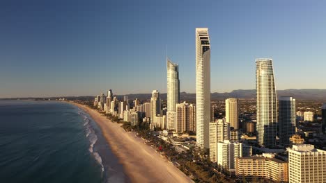 Beautiful-aerial-sunrise-on-the-Gold-Coast-with-nice-beach,-ocean-and-swimmers-for-a-perfect-holiday-destination-in-summer