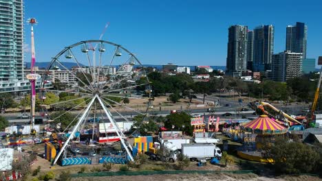 Vista-Aérea-De-Un-Carnaval-Junto-A-La-Playa-Junto-A-Una-Concurrida-Calle-Principal-Con-Edificios-En-El-Fondo