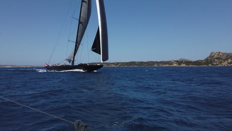 Un-Velero-Negro-Gigante-Navega-En-El-Parque-Nacional-De-La-Maddalena,-Cerdeña