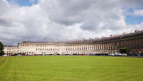 Zeitlupenschwenk-Von-Links-Nach-Rechts-Des-Royal-Crescent-In-Bath,-Somerset-An-Einem-Sonnigen-Sommertag-Mit-Blauem-Himmel-Und-Weißen-Wolken