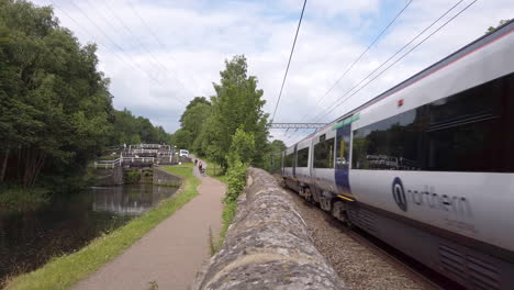 Toma-Estática-De-Un-Tren-Del-Norte-Que-Pasa-Por-Las-Esclusas-Del-Canal-Mientras-Se-Aleja-De-Leeds-En-Un-Día-De-Verano-En-Cámara-Lenta