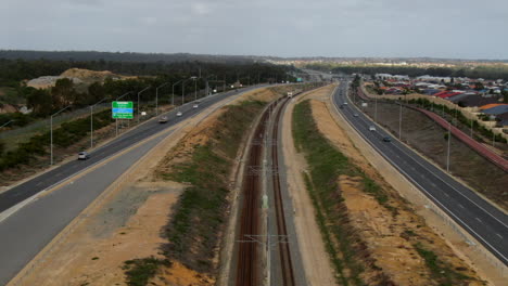 Luftaufnahme-Eines-Zuges,-Der-Auf-Der-Joondalup-Butler-Linie-Zwischen-Clarkson-Und-Butler-Station-In-Perth,-Westaustralien,-Fährt