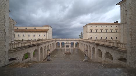 Patio-Vacío-Y-Desolado-En-La-Abadía-De-Montecassino-Con-Arcos-Estructura-Monumental-Con-Ominoso-Cielo-Gris-Espeluznante,-Italia,-Pandemia-De-Covid-19,-Estático