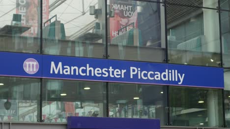 Señal-De-La-Estación-De-Manchester-Piccadilly-Fuera-De-La-Estación-Iluminación-De-Día-Nublado-Estación-De-Tren-Básica-Plana-Edificio-De-Transporte-Público-Estación-Principal-Reino-Unido-4k-25p